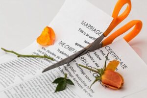 Scissors cutting into paper with flowers on top